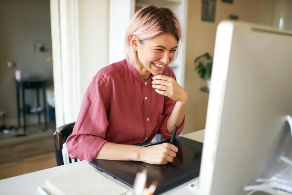 woman with pink hair smiling at computer meeting proforma solutions